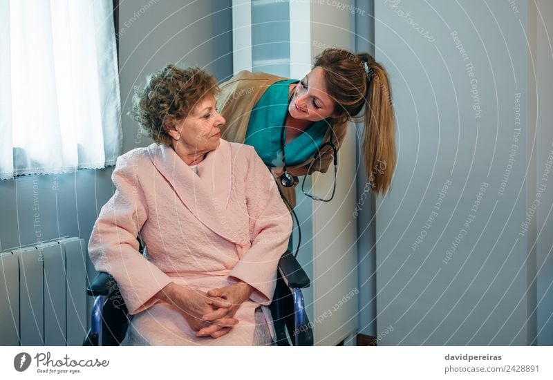 Arzt im Gespräch mit einem älteren Patienten im Rollstuhl Gesundheitswesen Krankheit Erholung Schlafzimmer Krankenhaus sprechen Mensch Frau Erwachsene alt