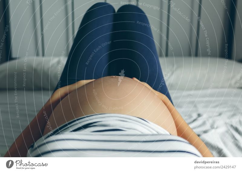 Schwangere Lügen, die ihren Bauch berühren. Lifestyle Körper Krankheit Schlafzimmer Mensch Frau Erwachsene Mutter Frauenbrust schlafen authentisch nackt