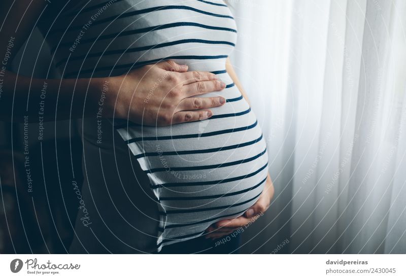Schwangere Frau hält ihren Bauch. Lifestyle Leben Schlafzimmer Kindererziehung Mensch Baby Erwachsene Mutter Hand warten authentisch schwanger Hoffnung Schmerz