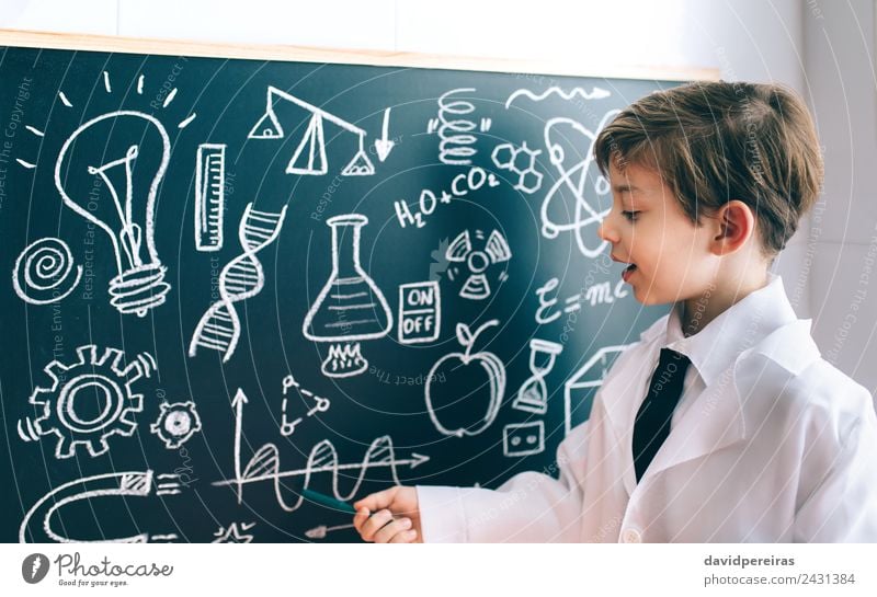 Seitenansicht des Jungen mit Zeichnung auf der Tafel Glück Spielen Wohnung Wissenschaften Kind Klassenraum Labor sprechen Mensch Kindheit authentisch klein