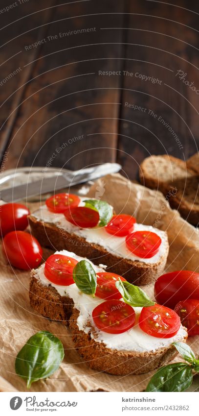 Bruschetta mit Frischkäse, Kirschtomaten und Basilikum Käse Brot Essen Frühstück Mittagessen frisch grün Amuse-Gueule Baguette Holzplatte Essen zubereiten Sahne