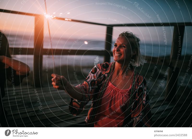 fröhliche junge erwachsene Frau mit Wunderkerze bei Sonnenuntergang am Strand Lifestyle Freude Glück schön Ferien & Urlaub & Reisen Sommer Meer Erwachsene Natur