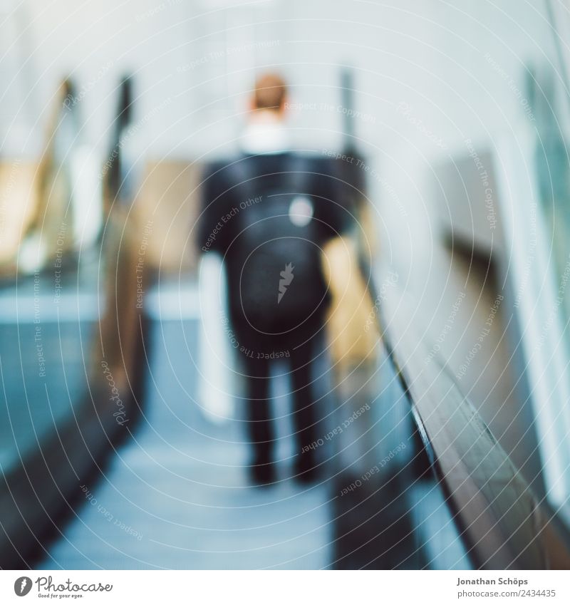Mann mit Taschen fährt auf einer Rolltreppe Flughafen Öffentlich U-Bahn Einkaufszentrum Einkaufscenter Personenverkehr Rucksack Stadt Stadtzentrum ästhetisch