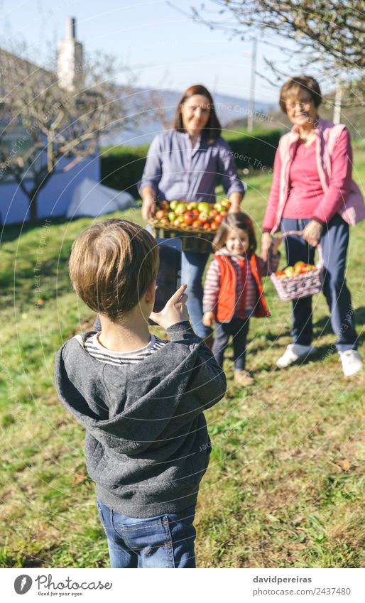 Junge fotografiert Familie mit Äpfeln im Korb Frucht Apfel Lifestyle Freude Glück Freizeit & Hobby Kind Mensch Frau Erwachsene Mann Mutter Großmutter