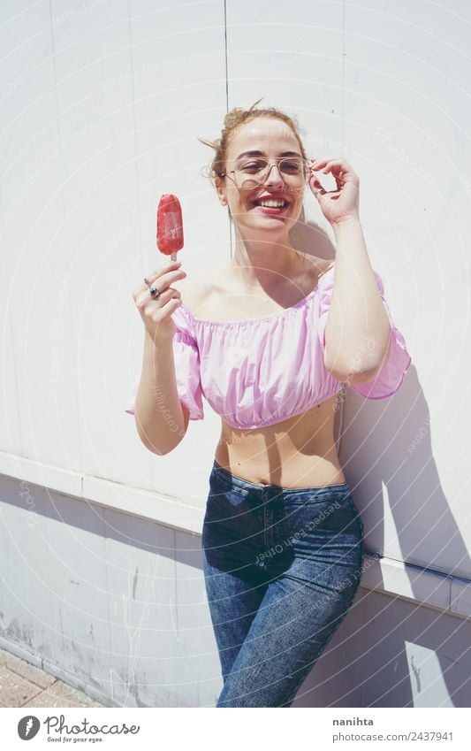 Junge blonde Frau beim Essen eines Eises im Sommer Lebensmittel Speiseeis Lifestyle Freude schön Sommerurlaub Sonne Sonnenbad Mensch feminin Junge Frau