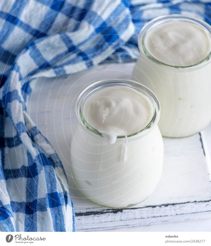 Glasgläser mit hausgemachtem Joghurt Lebensmittel Milcherzeugnisse Ernährung Frühstück Diät Tisch Holz frisch blau weiß Griechen Gesundheit Serviette