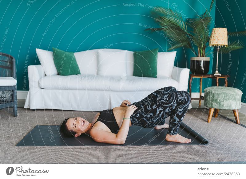 glückliche junge Frau, die Yoga auf einer Fitnessmatte zu Hause praktiziert. Lifestyle Freude Glück schön Körper Gesicht Leben Wohnzimmer Sport Mensch