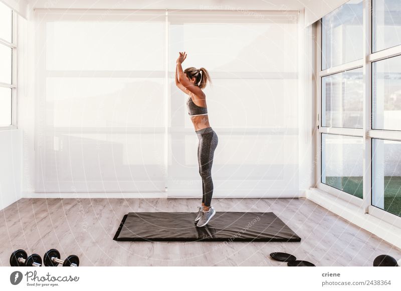 junge kaukasische Frau beim Fitness auf der Matte zu Hause Lifestyle Stil schön Körper Wellness Sport Erwachsene springen sportlich dünn hell modern üben