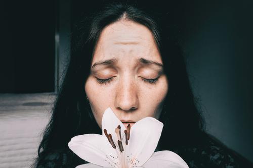 ein Mädchen mit einer weißen Lilie und geschlossenen Augen, besorgt. Lifestyle schön Gesicht Erholung Windstille Mensch feminin Junge Frau Jugendliche