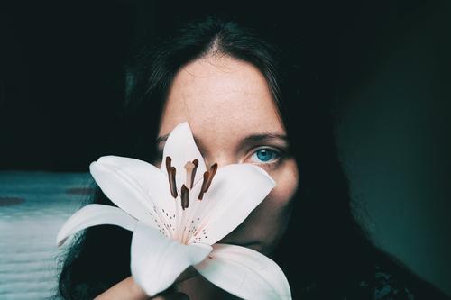 ein Mädchen mit einer weißen Lilie, die ein Auge bedeckt. Lifestyle schön Gesicht Erholung Windstille Mensch feminin Junge Frau Jugendliche Erwachsene 1