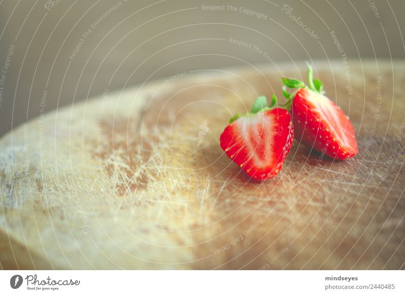 Eine aufgeschnittene Erdbeere auf Holzbrett Frucht Erdbeeren Ernährung Vegetarische Ernährung Fasten Sommer Küche Natur Pflanze Essen Fitness genießen