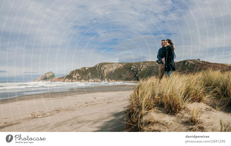 Ein Paar schaut auf das Meer. Lifestyle ruhig Freizeit & Hobby Strand Wellen Winter Frau Erwachsene Mann Eltern Familie & Verwandtschaft Natur Landschaft Sand