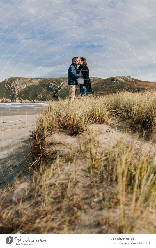 Ein Paar küsst sich am Strand. Lifestyle ruhig Freizeit & Hobby Meer Wellen Winter Frau Erwachsene Mann Eltern Familie & Verwandtschaft Natur Landschaft Sand