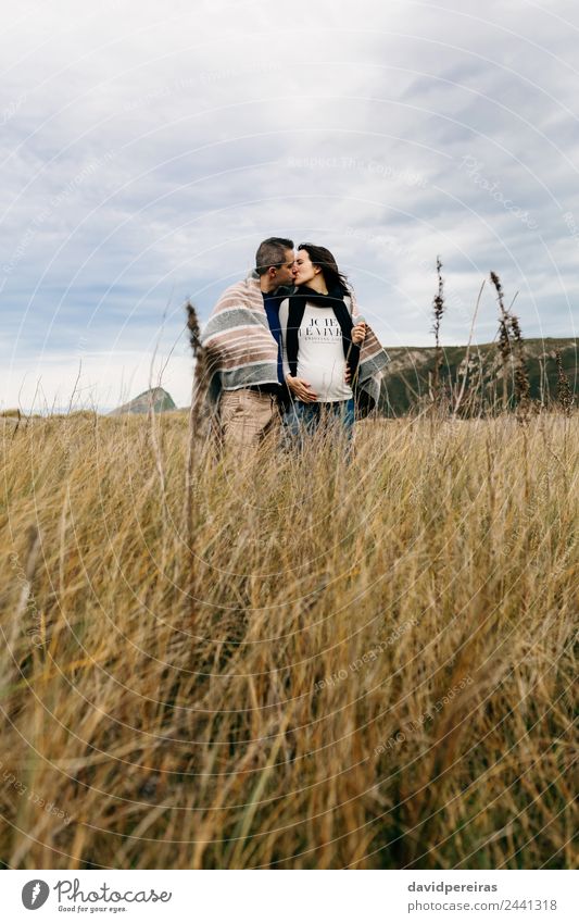 Ein Paar küsst sich auf dem Feld. Lifestyle ruhig Freizeit & Hobby Winter Frau Erwachsene Mann Eltern Familie & Verwandtschaft Natur Landschaft Wolken Herbst
