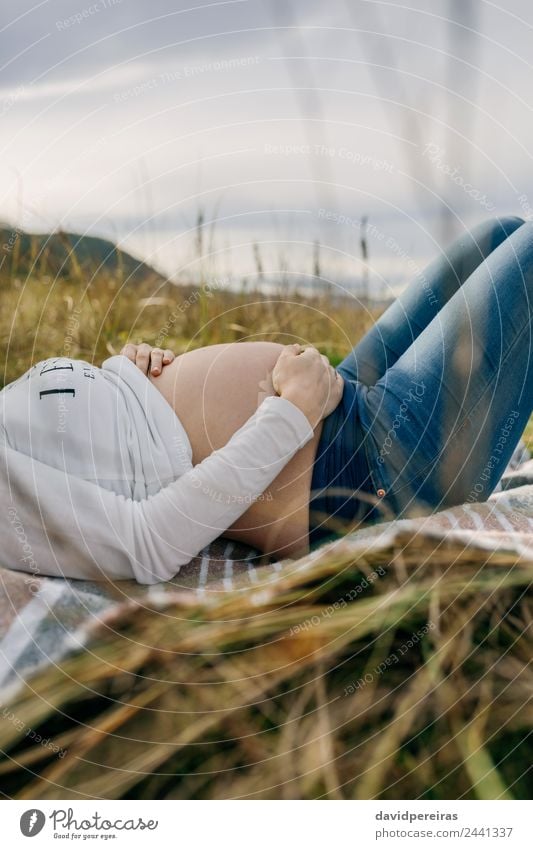 Schwangere Frau, die ihren Bauch streichelt und schläft. Lifestyle schön Erholung Mensch Baby Erwachsene Mutter Familie & Verwandtschaft Natur Landschaft Gras