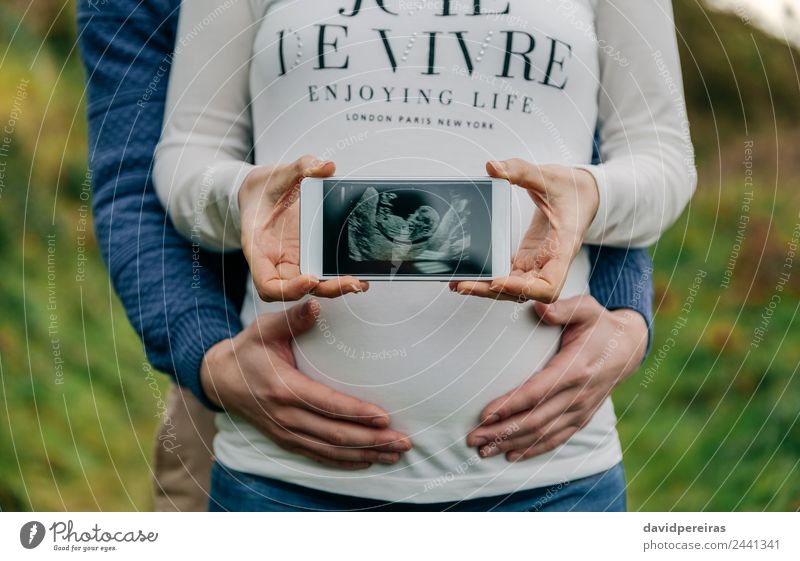 Schwangere zeigt mit ihrer Partnerin Ultraschall auf dem Handy. Lifestyle Leben PDA Technik & Technologie Mensch Baby Frau Erwachsene Mann Eltern Mutter Paar