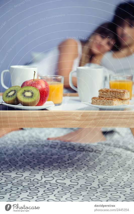 Gesundes Frühstück auf Tablett und im Hintergrund liegendes Paar Frucht Apfel Saft Kaffee Lifestyle Glück schön Erholung Freizeit & Hobby Schlafzimmer Frau