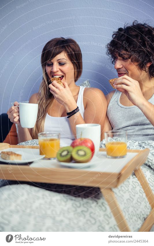 Paar beim Frühstück im Bett, serviert auf dem Tablett. Frucht Apfel Saft Kaffee Lifestyle Glück schön Erholung Freizeit & Hobby Schlafzimmer Frau Erwachsene
