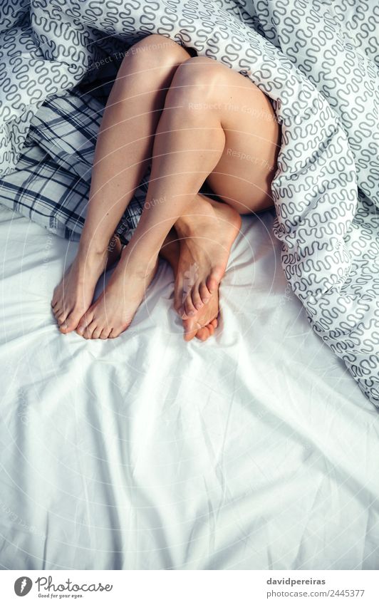 Verliebtes Paar liegt auf dem Bett mit gekreuzten Beinen. Lifestyle Glück schön Erholung Schlafzimmer Frau Erwachsene Mann Familie & Verwandtschaft Fuß Liebe