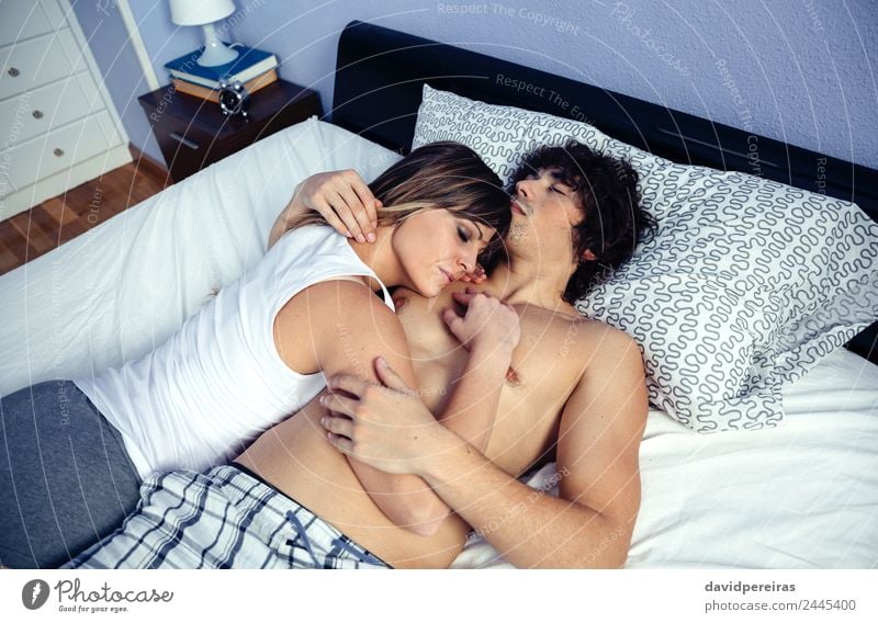 Junges verliebtes Paar, das sich umarmt und über einem Bett liegt. Lifestyle Glück schön Erholung Schlafzimmer Frau Erwachsene Mann Familie & Verwandtschaft