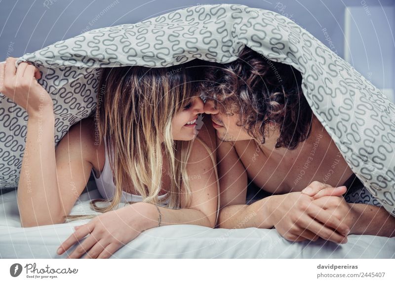 Glückliches junges Paar in der Liebe küsst sich unter dem Bettbezug. Lifestyle schön Erholung Schlafzimmer Frau Erwachsene Mann Familie & Verwandtschaft Küssen