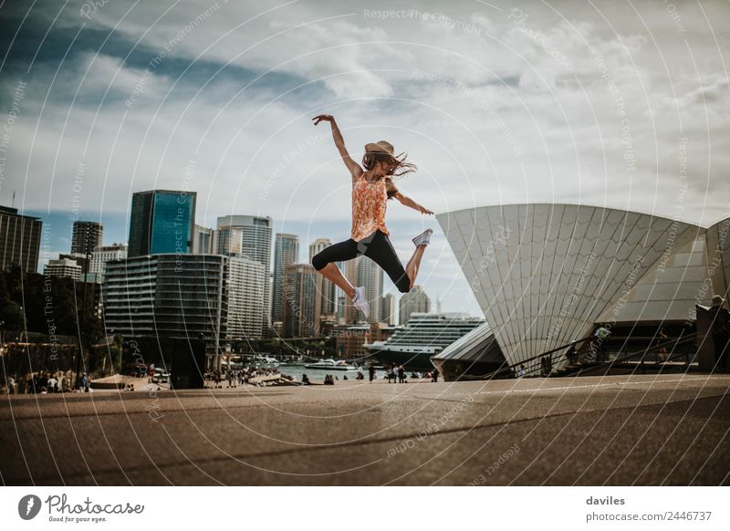 Dünnes Mädchen, das vor Energie springt, mit der Stadtlandschaft von Sydney und dem Opernhaus im Hintergrund. Lifestyle Freude Freizeit & Hobby