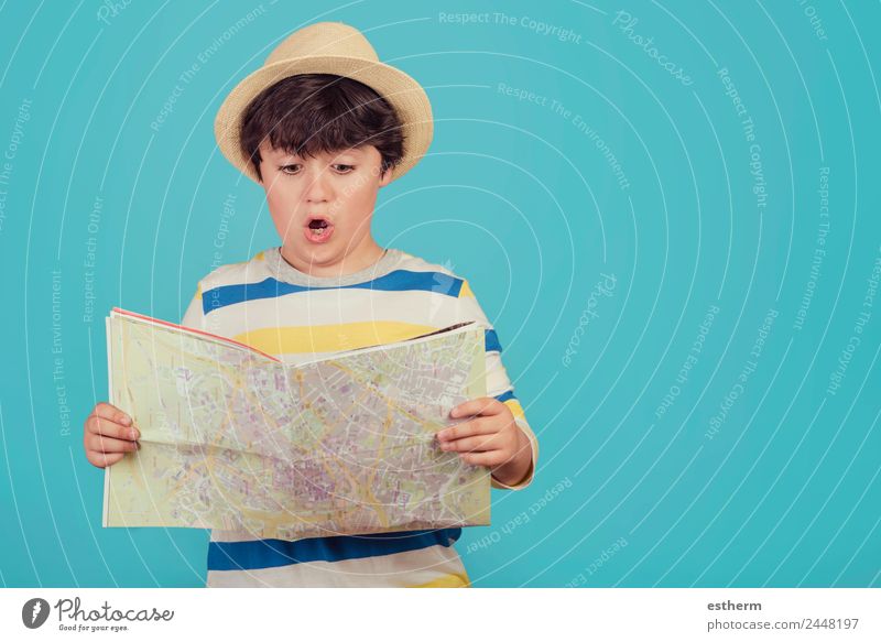 Junge mit Hut und Karte auf blauem Hintergrund Lifestyle Ferien & Urlaub & Reisen Tourismus Ausflug Abenteuer Sightseeing Städtereise Sommerurlaub Mensch