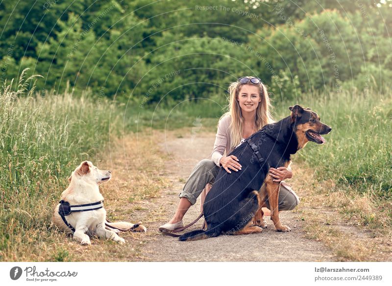 Glückliche blonde Frau mit ihren beiden treuen Hunden schön Freizeit & Hobby Sommer Erwachsene Freundschaft 1 Mensch 18-30 Jahre Jugendliche Landschaft Park 2