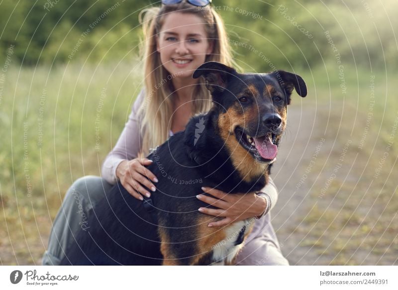Hübsche blonde Frau mit ihren beiden Hunden. Glück Gesicht Sommer Erwachsene Freundschaft 1 Mensch 18-30 Jahre Jugendliche Tier Wärme Gras Wiese Haustier