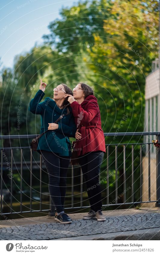 fröhliche Zwillingsschwestern stehen auf einer Brücke und schauen nach oben Lifestyle Stil Freude Glück Mensch feminin Junge Frau Jugendliche Geschwister