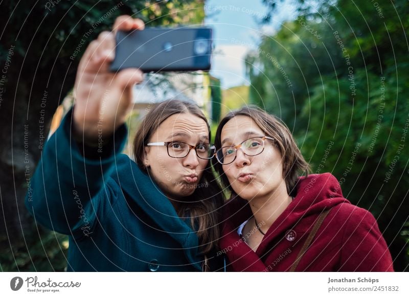 lustige Zwillingsschwestern machen ein Selfie mit dem Smartphone Lifestyle Freude Glück Mensch feminin Junge Frau Jugendliche Geschwister Schwester Leben 2