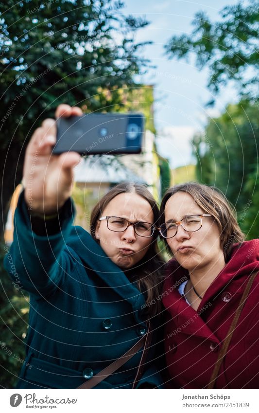 lustige Zwillingsschwestern machen ein Selfie mit dem Smartphone Lifestyle Freude Glück Mensch feminin Junge Frau Jugendliche Geschwister Schwester Leben 2