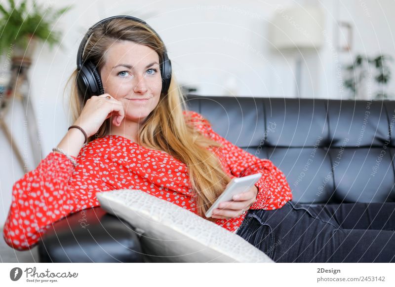 Glückliche Frau, die mit Kopfhörern Musik hört. Lifestyle Freude schön Erholung ruhig Freizeit & Hobby Spielen Sofa Telefon PDA Technik & Technologie Internet