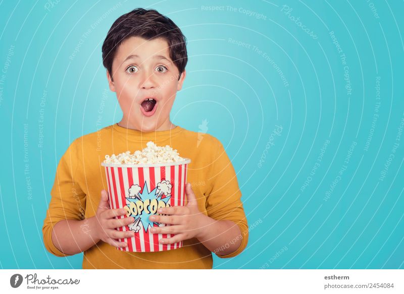 glücklicher Junge mit Popcorn auf blauem Hintergrund Lebensmittel Lifestyle Freude Freizeit & Hobby Entertainment Mensch maskulin Kind Kleinkind Kindheit 1
