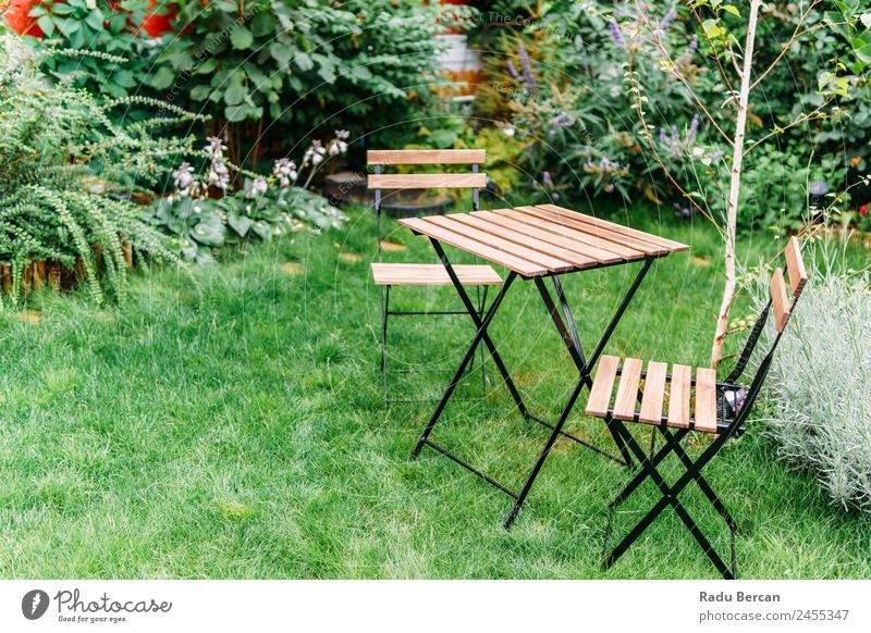 Tisch und Stühle im kleinen grünen Intimgarten Garten Möbel Stuhl Außenaufnahme Terrasse Sommer Englisch Holz Gras Natur Rasen Haus Hof Sonnenstrahlen Frühling