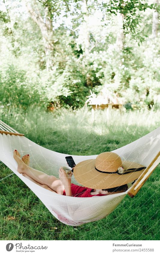 Young woman relaxing in a hammok Junge Frau Jugendliche Erwachsene 1 Mensch 18-30 Jahre 30-45 Jahre Natur Erholung Garten Hängematte Pause Schatten sommerhut