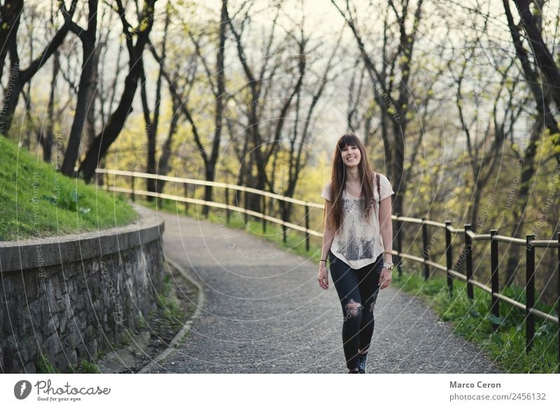 Hübsche junge Frau lächelt und geht glücklich im Park spazieren Erwachsener allein attraktiv Herbst Hintergrund schön Schönheit braun Windstille Kaukasier