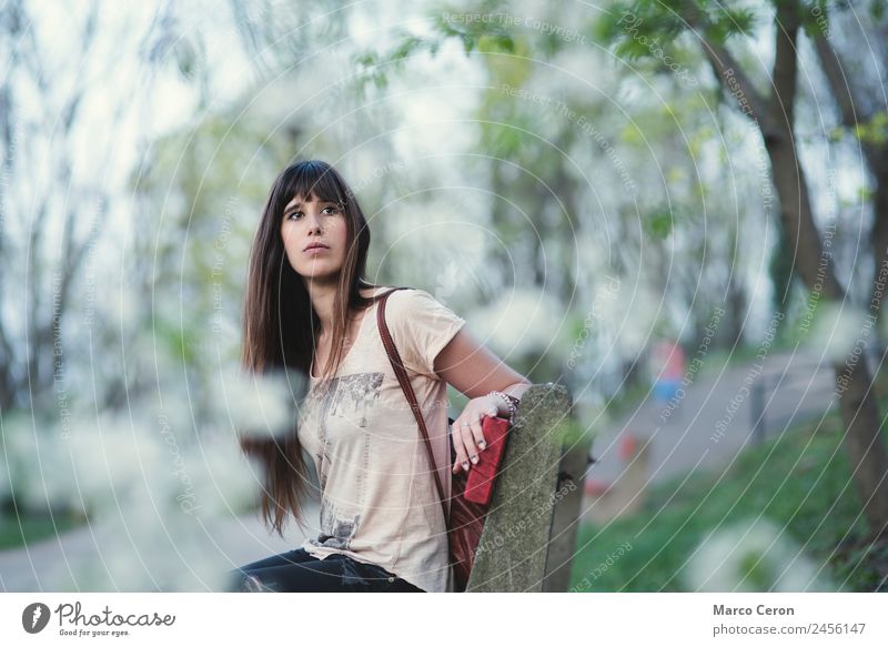 Attraktive junge Frau, die auf einer Bank in einem Park sitzt. Lifestyle schön Haare & Frisuren Nagellack Erholung ruhig Ferien & Urlaub & Reisen Sommer Mensch