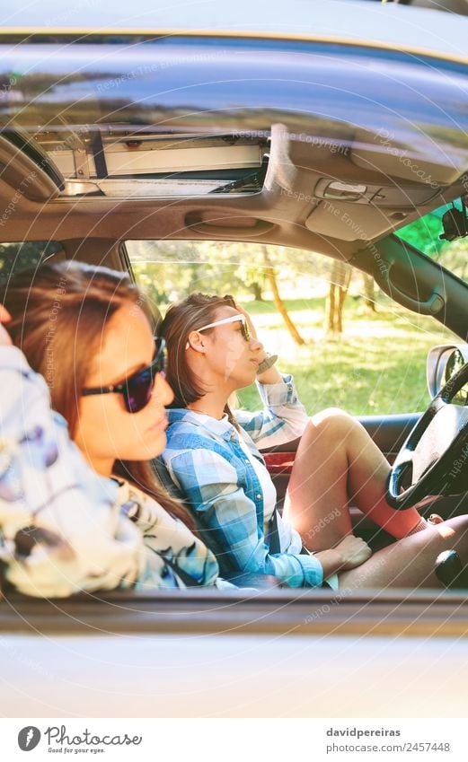 Zwei junge Frauen, die im Auto sitzen und sich ausruhen. Lifestyle Freude Glück schön Erholung Freizeit & Hobby Ferien & Urlaub & Reisen Ausflug Sommer Sonne