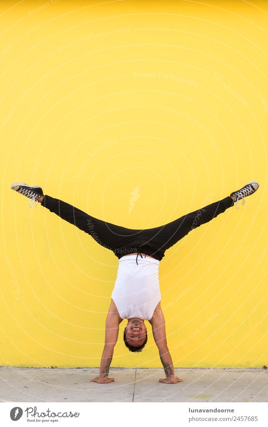 Mann praktiziert Yoga, Handstand an einer gelben Wand Lifestyle Freude sportlich Fitness Leben Wohlgefühl Sport Sport-Training Leichtathletik Tanzen Mensch