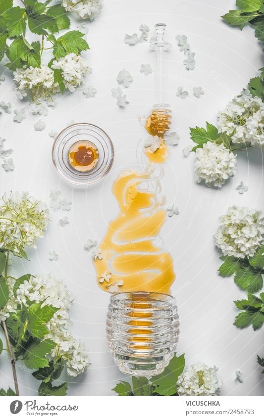 Fließender Honig mit Blumen und Honiglöffel Lebensmittel Ernährung Bioprodukte Vegetarische Ernährung Diät Geschirr Stil Design Gesundheit Alternativmedizin