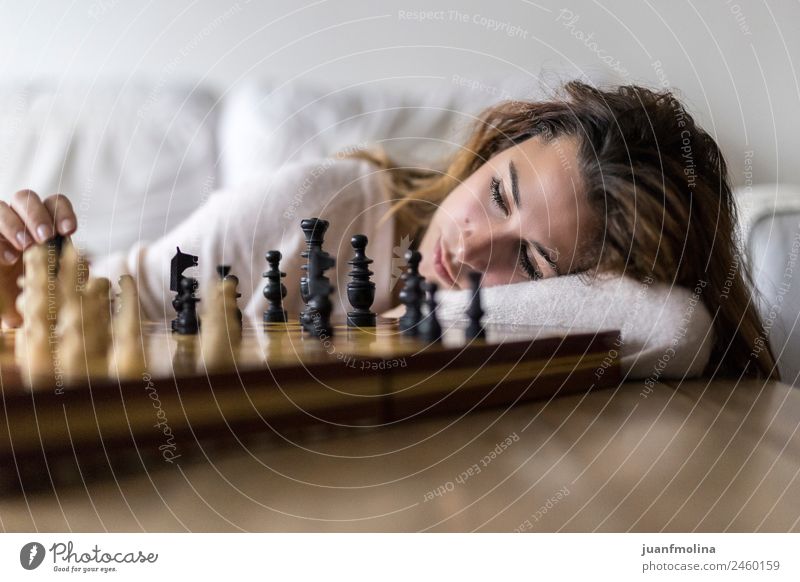 Frau zu Hause, die allein Schach spielt. Lifestyle elegant Stil Glück schön Gesicht Leben Freizeit & Hobby Spielen Traumhaus Sofa Tisch Raum Wohnzimmer