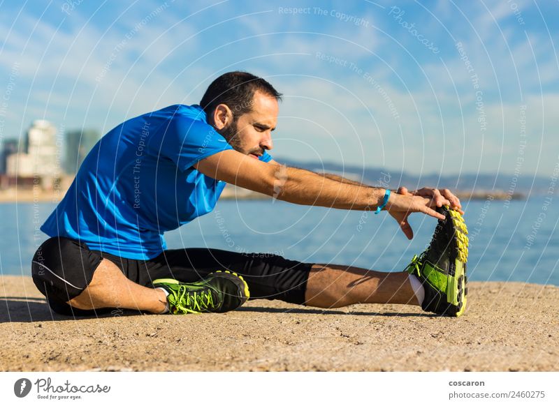 Jogger, der sich am Morgen am Meer ausdehnt. Lifestyle Körper Wellness Leben Erholung Freiheit Strand Sport Mann Erwachsene Natur Horizont Küste Vollbart