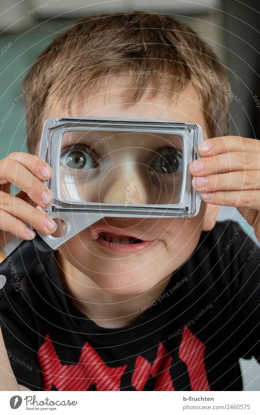 Kind mit Leselupe Kindergarten Schule Büro Gesicht Auge 3-8 Jahre Kindheit Glas beobachten entdecken festhalten Fröhlichkeit Neugier Optimismus Abenteuer