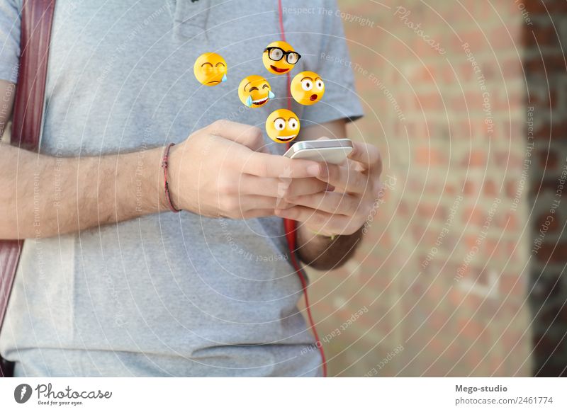 Mann, der ein Smartphone benutzt, das Emojis sendet. Lifestyle Glück Gesicht Telefon PDA Bildschirm Technik & Technologie Internet Mensch Erwachsene Hand lustig
