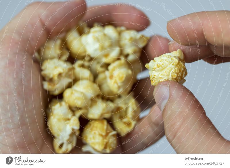 Popcorn Getreide Süßwaren Hand Finger Essen festhalten Popkorn Entertainment ungesund Kino Snack Farbfoto Innenaufnahme Studioaufnahme Nahaufnahme