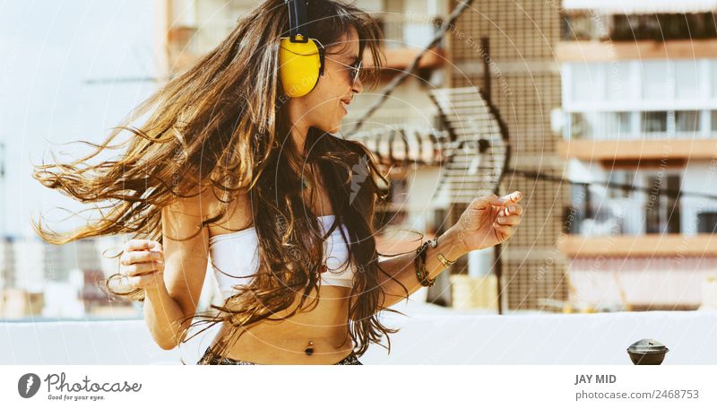 fröhliche Frau mit langen Haaren auf Kopfhörer hört Musik. Lifestyle Stil Freude Glück schön Freiheit Sommer Tanzen Telefon Headset Mensch Erwachsene 1 Skyline