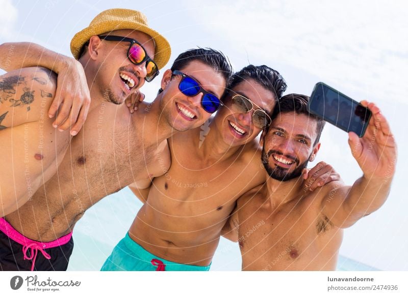 Vier Lateinamerikaner mit einem Selfie am Strand. Lifestyle Stil Freude Ferien & Urlaub & Reisen Tourismus Sonne Homosexualität Mann Erwachsene Freundschaft