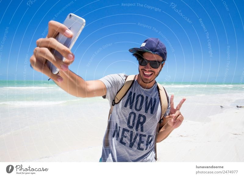 Millenialer Reisender mit einem Selfie Lifestyle Freude Ferien & Urlaub & Reisen Sommer Strand Mensch Mann Erwachsene Sonnenbrille Hut Lächeln exotisch Glück