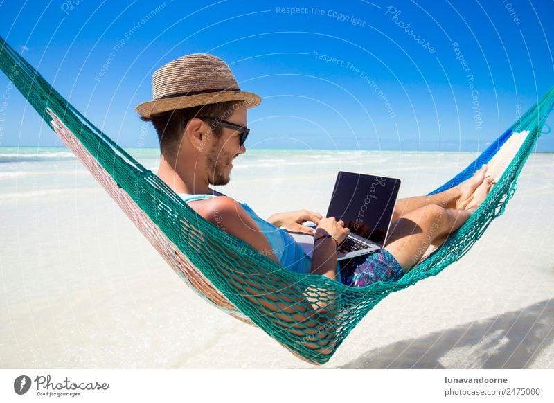 Digitaler Nomade, Fernarbeiter mit einem Laptop auf einer Hängematte Lifestyle Erholung Ferien & Urlaub & Reisen Sommer Strand Arbeit & Erwerbstätigkeit